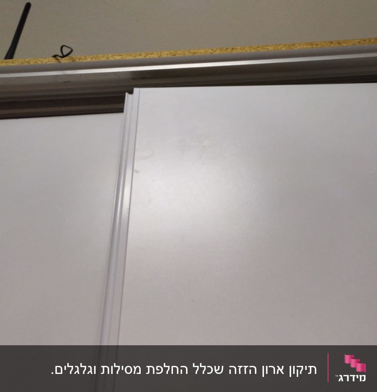דלת הזזה לבנה עם מסגרת מתכת עליונה